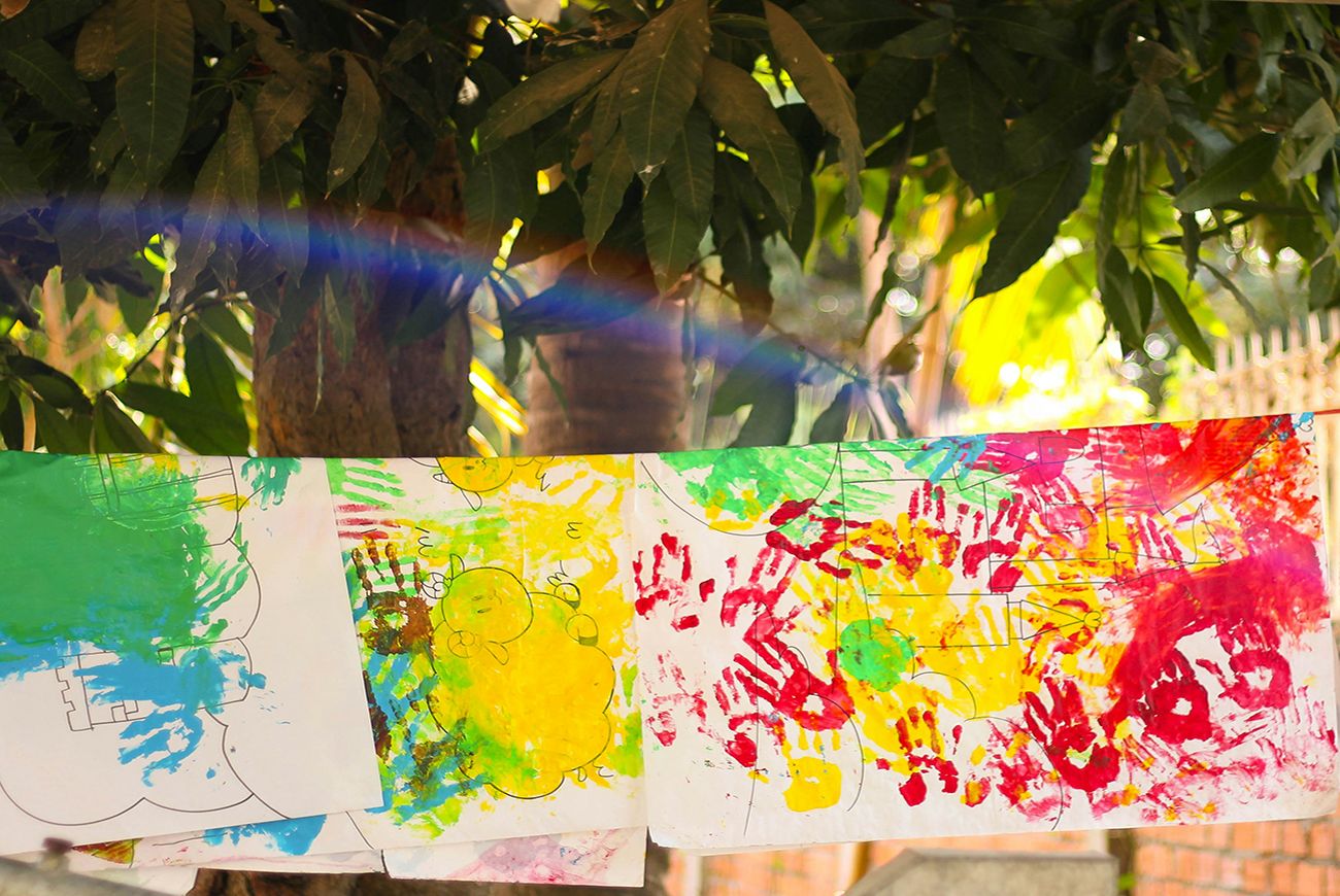 A large colourful childs painting dries in the sun