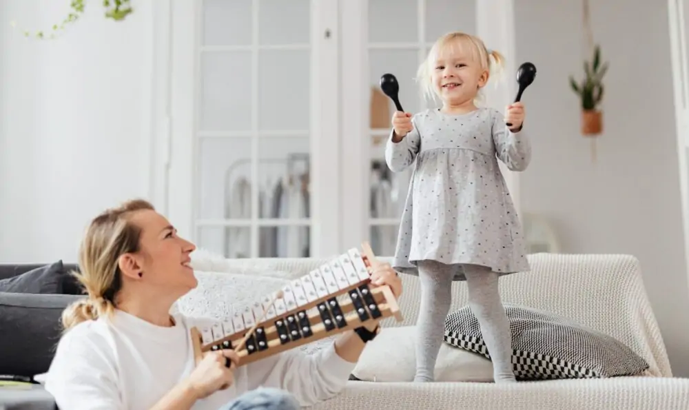 child playing music with mum.