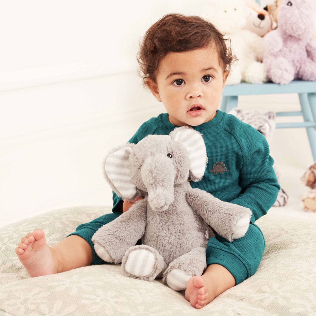 Baby with elephant plush toy.