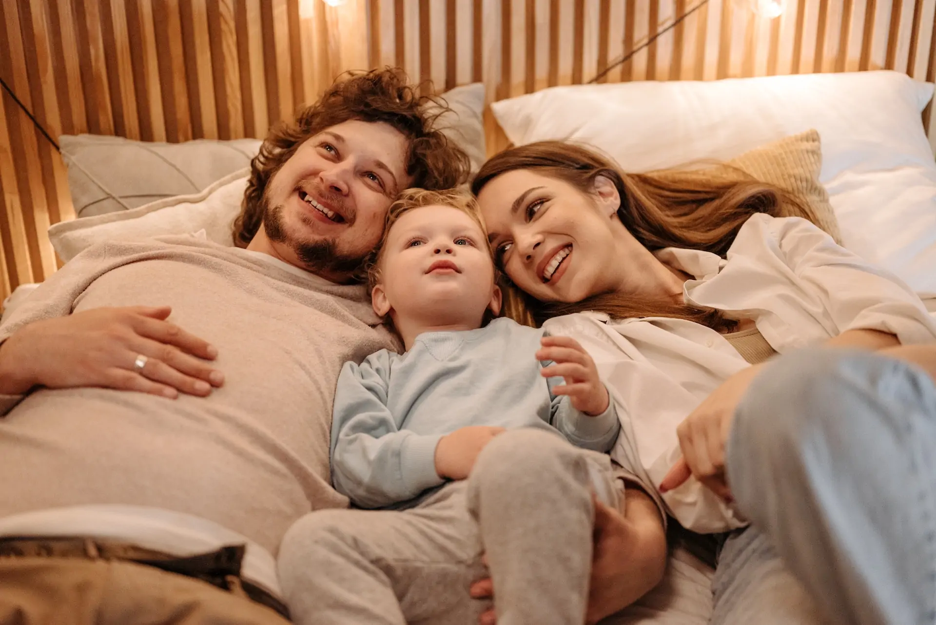 Family in bed together smiling.